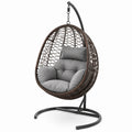 Sillón colgante de ratán sintético con estructura de acero y cojines grises